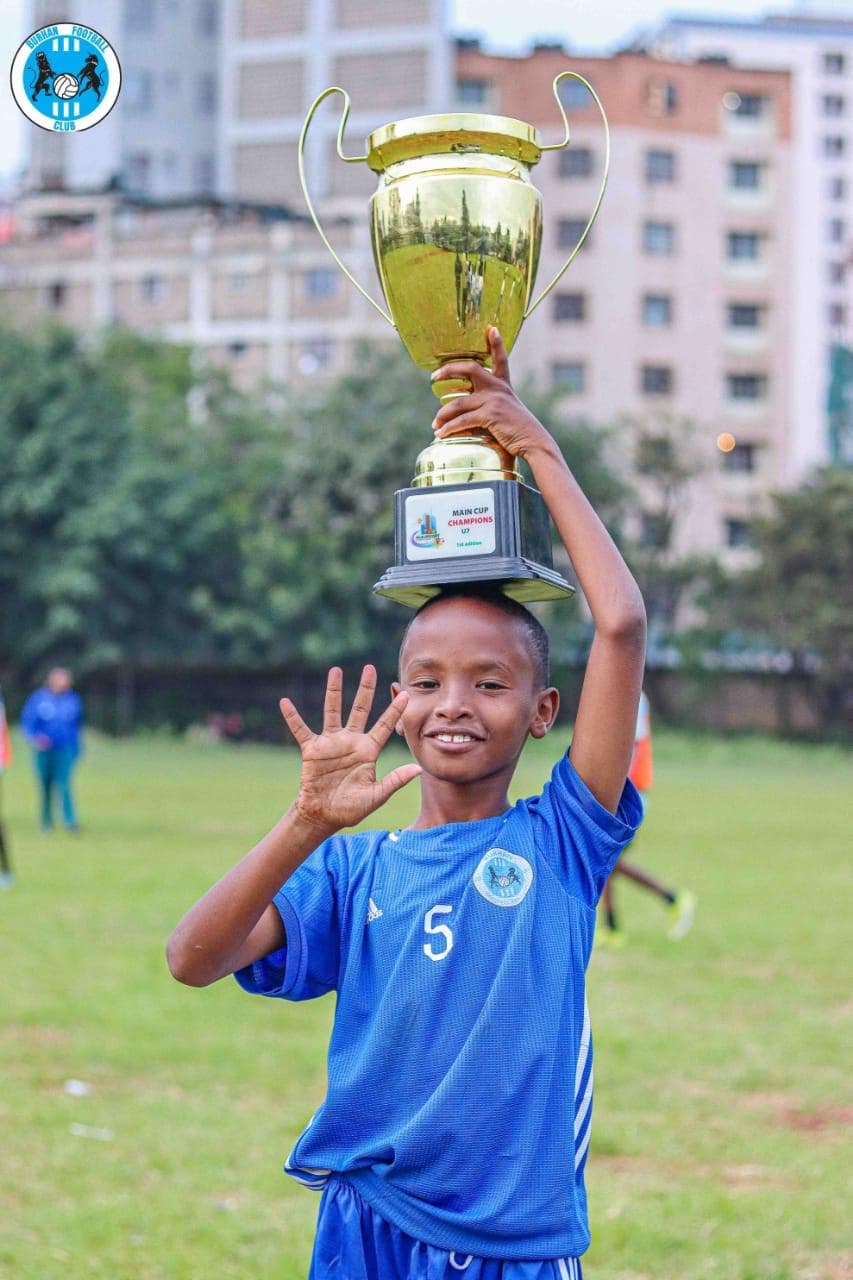 Burhan Football Academy players celebrating championship trophy lift