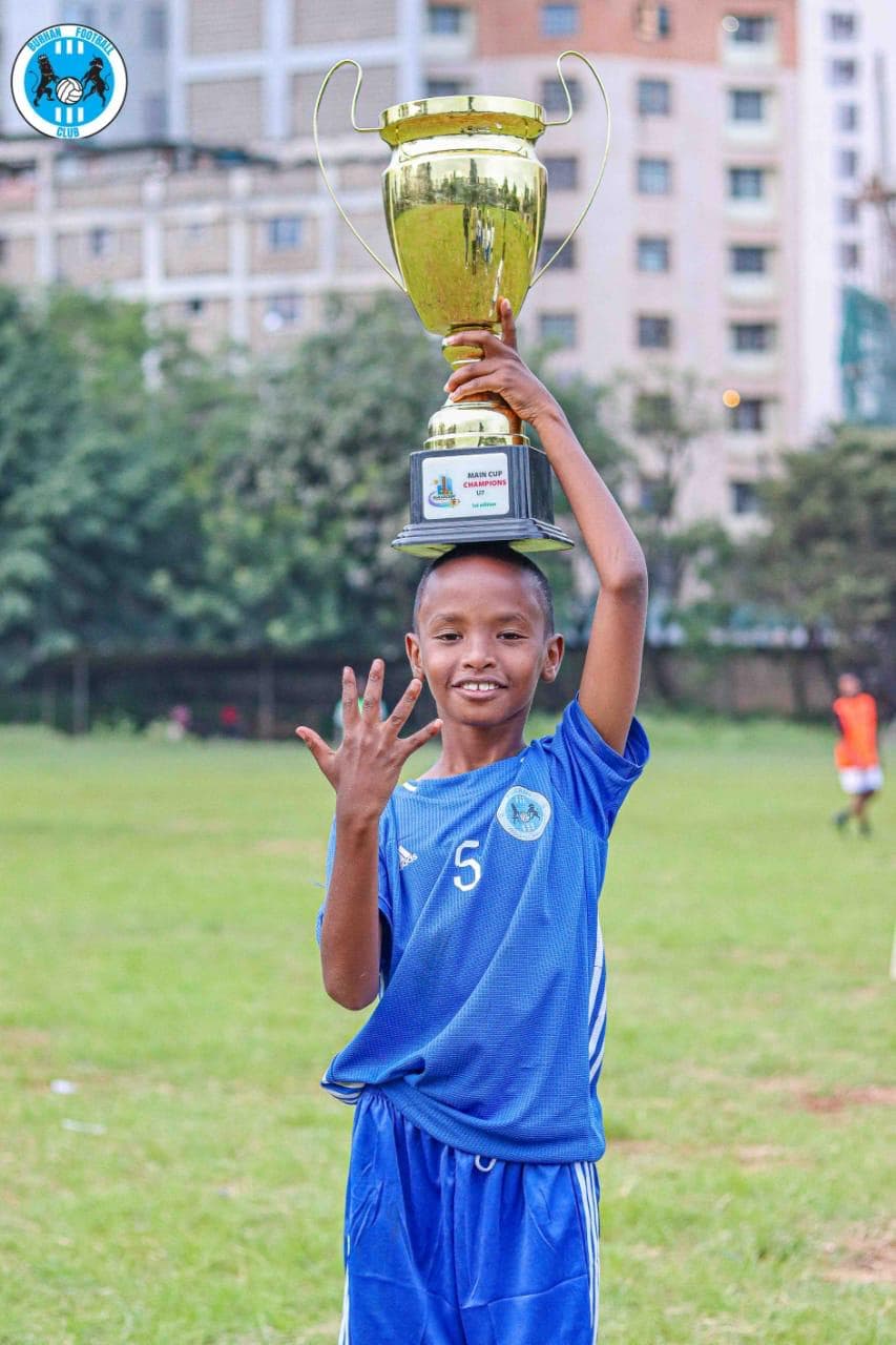 Academy youth champion waving with pride and trophy